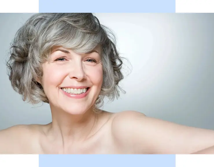 A woman with grey hair smiling for the camera.